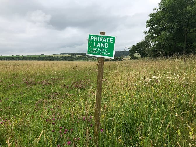 Табличка з написом Private land вкопана в полі